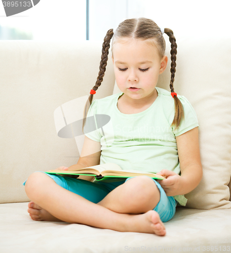 Image of Little girl reads a book