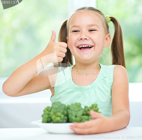 Image of Cute little girl is eating green grapes