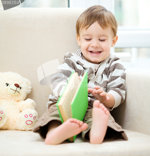 Image of Little boy is reading book