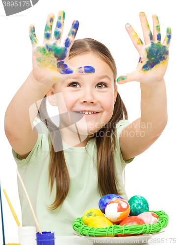 Image of Little girl is painting eggs preparing for Easter