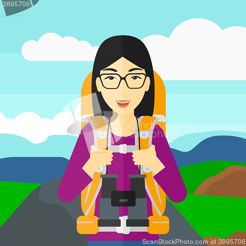 Image of Cheerful backpacker with binoculars.