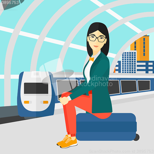 Image of Woman sitting on railway platform.