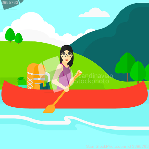 Image of Woman canoeing on the river.