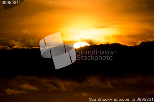 Image of sunset with sun clouds over clouds