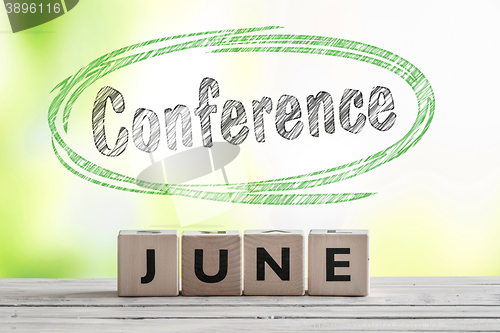 Image of June conference sign on a wooden stage