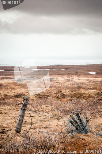 Image of Barb wire on a fence in cloudy weather