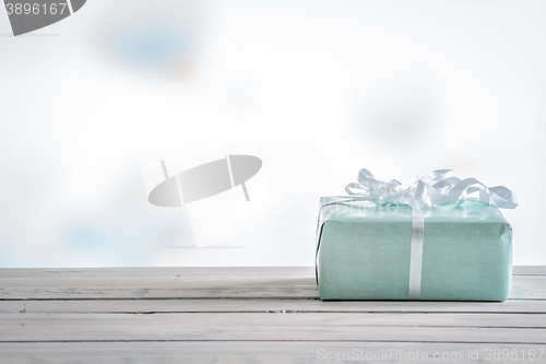 Image of Gift in blue color on a wooden table