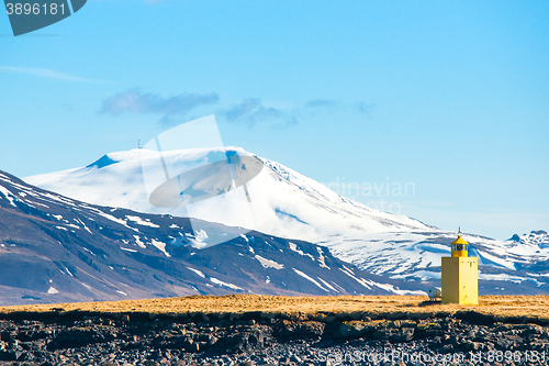 Image of Small lighthouse on an island with mountains