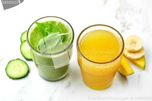Image of Glasses of green smoothie and yellow juice