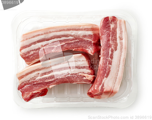 Image of raw bacon pieces in plastic try