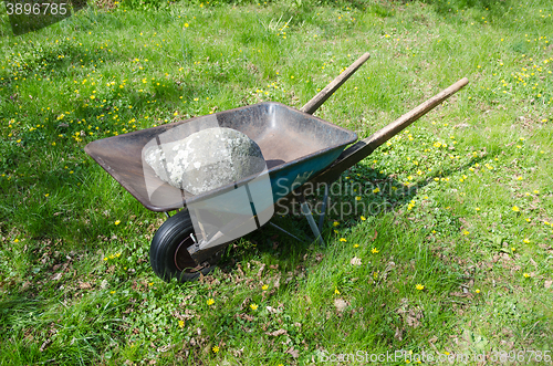 Image of Wheelbarrow with a big stone