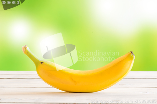 Image of Single banana on a wooden desk