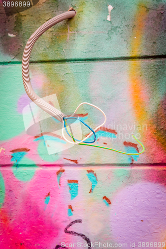 Image of Wires coming out of a grungy wall with grafitti