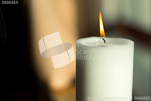 Image of Large candle with a burning flame