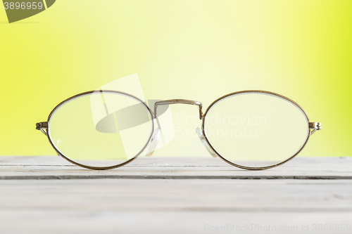 Image of Glasses on a table on green background