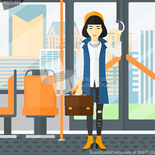 Image of Woman standing inside public transport.