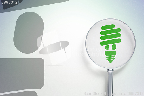 Image of Business concept:  Energy Saving Lamp with optical glass on digital background