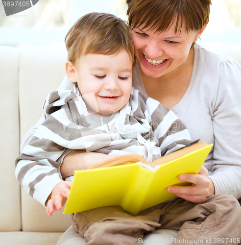 Image of Mother is reading book for her son