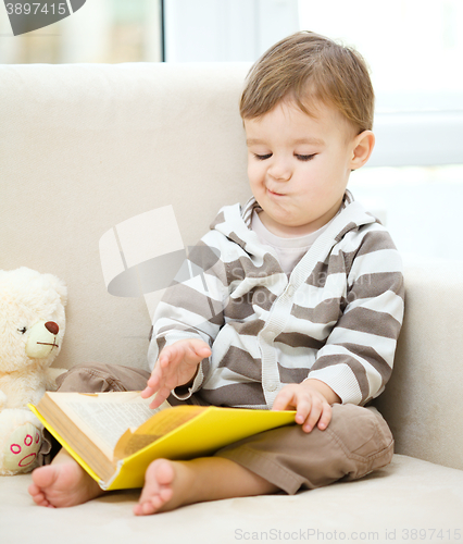 Image of Little boy is reading book