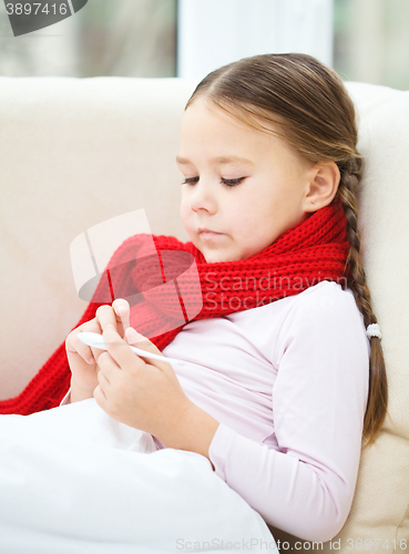 Image of Ill little girl is reading thermometer