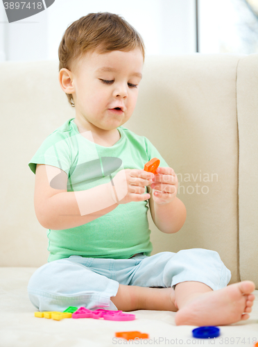 Image of Little boy playing with toys