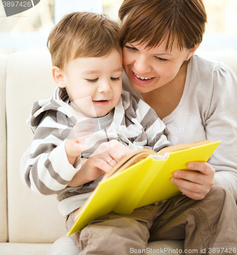 Image of Mother is reading book for her son