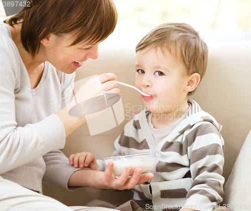 Image of Cute little boy is fed using spoon