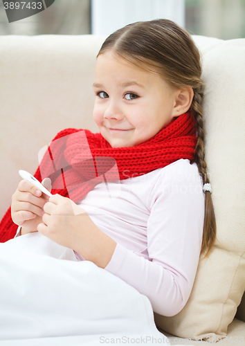 Image of Ill little girl is reading thermometer