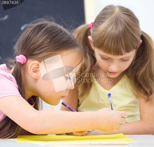 Image of Little girls are writing using a pen