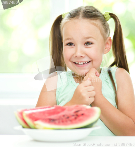 Image of Cute little girl is eating watermelon