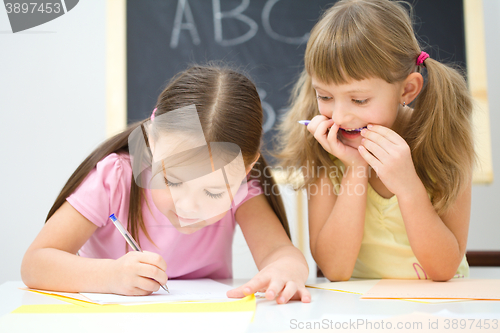 Image of Little girls are writing using a pen