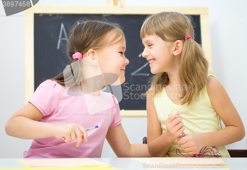 Image of Little girls are writing using a pen