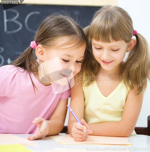 Image of Little girls are writing using a pen