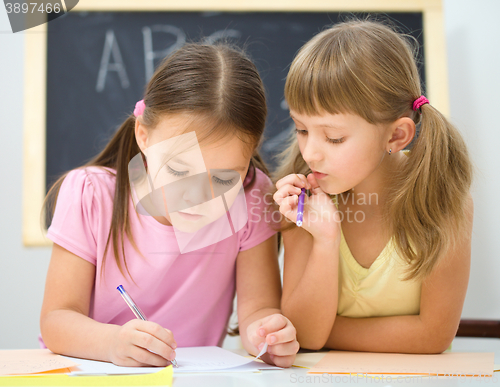 Image of Little girls are writing using a pen