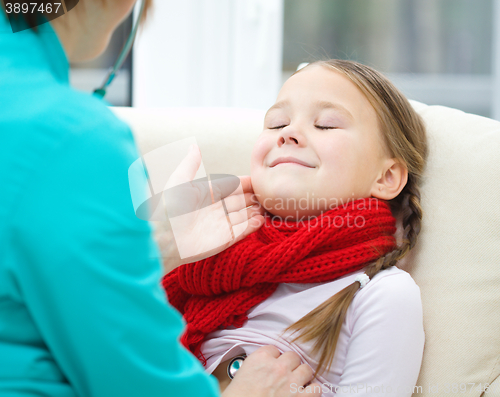 Image of Doctor is examining little girl