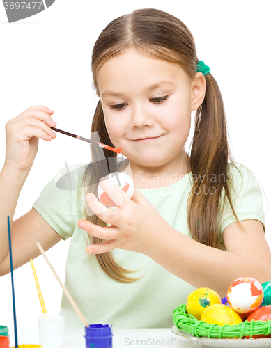 Image of Little girl is painting eggs preparing for Easter