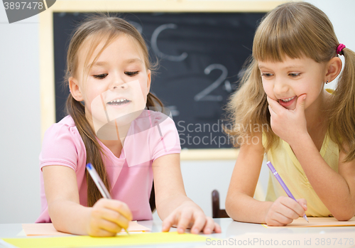 Image of Little girls are writing using a pen