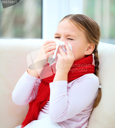 Image of Little girl is blowing her nose