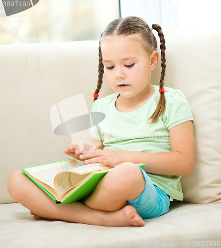 Image of Little girl reads a book