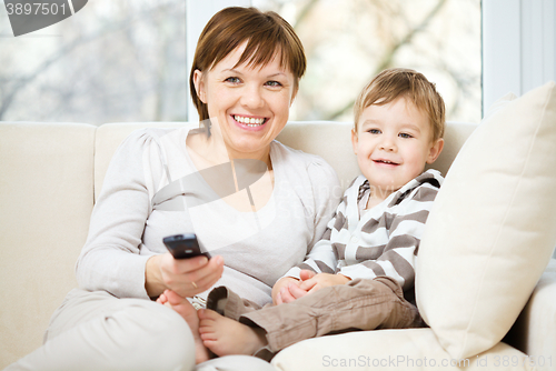 Image of Mother and her son are watching tv show