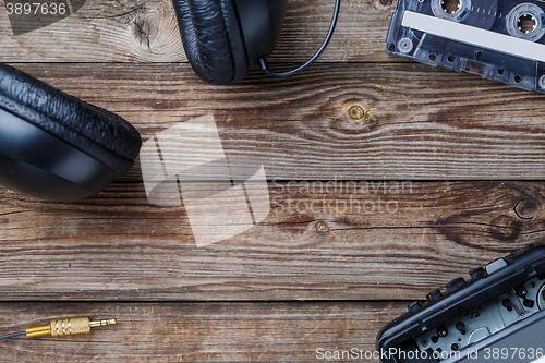 Image of Cassette tapes, player and headphones over wooden table. top view.