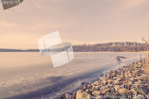 Image of Frozen river landscape with pebbles