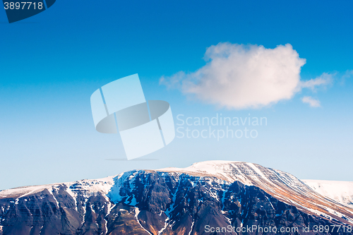 Image of Fluffy white cloud over a mountain top