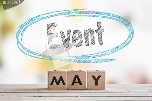 Image of May event sign on a wooden table