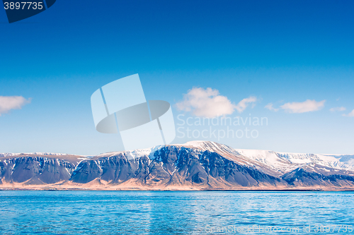 Image of Skies over a mountain with snow by the sea