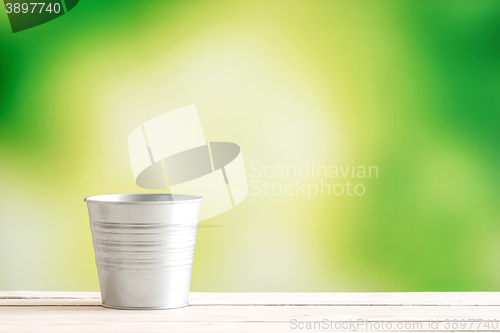 Image of Metal bucket on a wooden desk