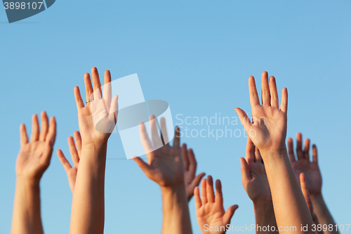 Image of Group of people raising their hands in the air