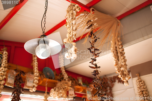 Image of Garlic and Peppers Hanging from Ceiling In Market