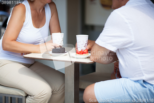 Image of Couple Enjoying Coffee and Desserts on Cafe Patio