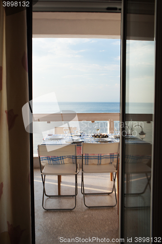 Image of Dining table set on a balcony overlooking the sea